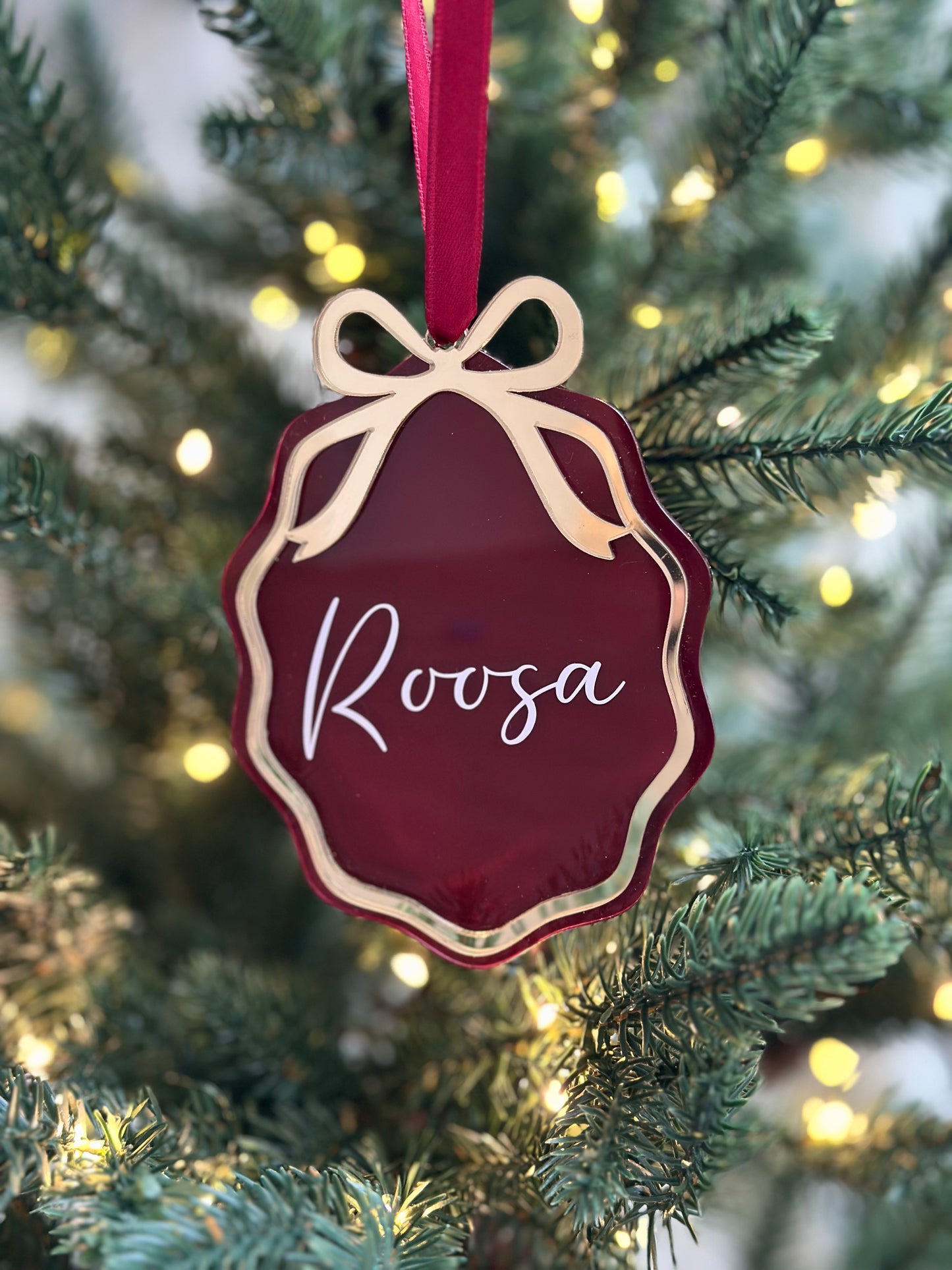 Aaltoreunainen joulukuusenkoriste rusetilla